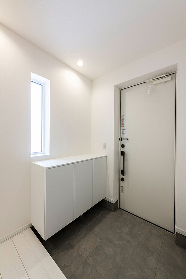 【【A棟 玄関】】白を基調とした、清潔感あふれる玄関。窓からやわらかな自然光が差し込み、空間を明るく演出します。靴箱も備えており、すっきりと整った玄関を保てます。(2026年3月撮影)