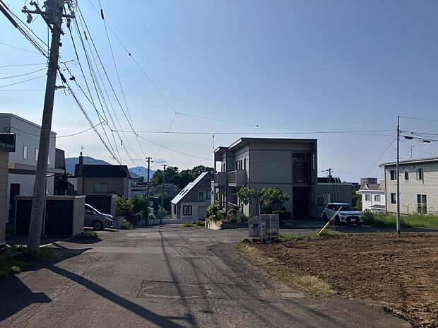 【【現地写真】】約8mの南西側道路と約6mの北西側道路に面した、開放感のある区画です。道路幅にゆとりがあり、車の出入りもしやすいですね。
（2026年6月撮影）
