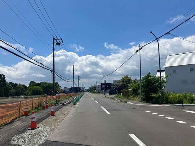 【【現地写真】】どこまでも続いていそうなまっすぐな道路。歩道も整備されており、毎日のお出掛けもしやすい立地です。
(2026年6月撮影)