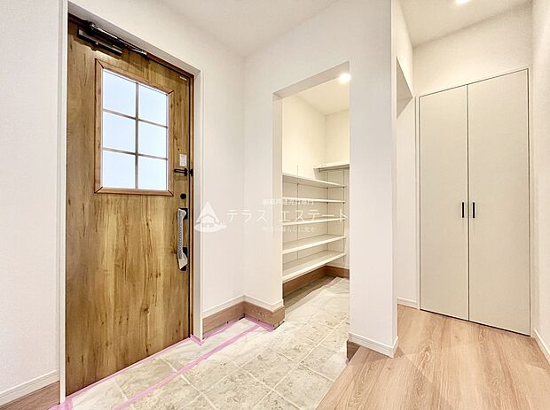 【玄関】木目調の玄関ドアが、落ち着いた雰囲気を演出してくれます。白を基調とした落ち着いた雰囲気の開放的な玄関スペースです。