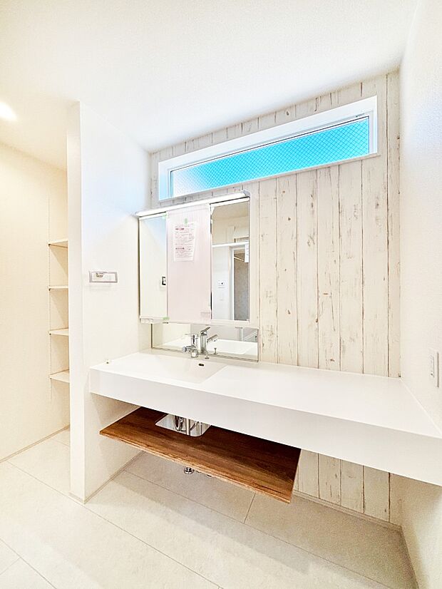 タオルや洗面用具のストック類を置ける便利な可動棚つきの洗面所。