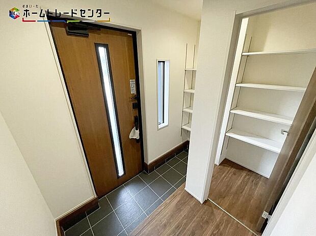 【玄関】２号棟訪れる人を優しく迎える、スタイリッシュな玄関。開放感のある玄関ホール。温もり感じるフローリング仕様ですので、ご家族やお客様を温かく迎えてくれます。