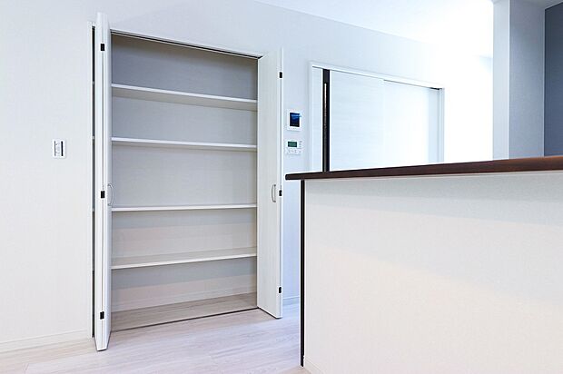 【リビング収納】リビングとキッチンの間には可動棚タイプの収納スペースを設け、パントリーや日用品等の使い方をすることができます。
