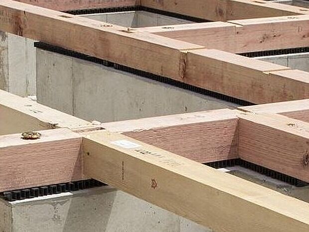 【剛性・耐久性にすぐれた「ベタ基礎」】コンクリートで建物の下一面を支える工法。　基礎鉄筋を張り、強度を高めたベタ基礎の耐圧盤を1階の床下全面に施工し、広い耐圧盤の面で建物の荷重を地盤に伝えます。