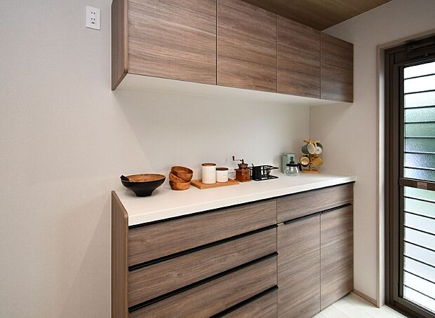 【キャビネット】キッチン背面にキャビネットが設置されているのはプレミアム仕様だけ!食器類はもちろん、ゴミ箱も隠せるので生活感も目立ちにくい♪※施工事例です。実際とは異なります。