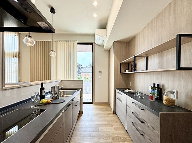 【【5号棟】キッチン】Panasonicラクシーナ。IHヒーターは3口横並びで使えるので、ゆったり広々料理できます。カップボードの収納も大容量。ダーク色のカウンターは存在感があり、空間をおしゃれに見せてくれます。