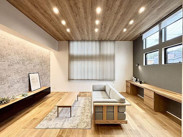 【13号棟】木目の天井と、質感豊かなアクセントウォールが調和し、温かみと洗練された雰囲気を演出しています。天井高3mの開放感と温かみのある心地よい空間で、ゆったりとくつろげます。