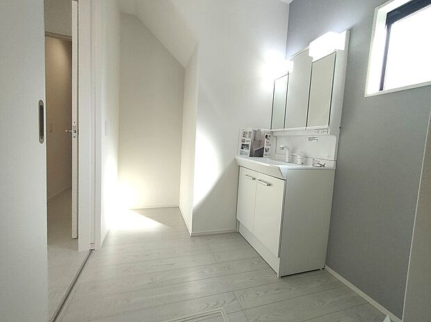 【洗面所】洗面台と鏡収納に加え、奥には階段下を活用した収納を備えた洗面所。採光のある明るい空間で、身支度や家事がしやすく、限られたスペースを無駄なく使える機能的なつくりです♪