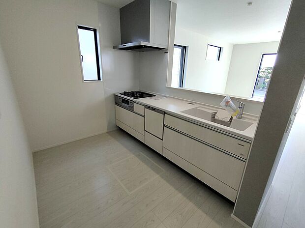 【キッチン(1号棟)】3口ガスコンロとレンジフードを備えた機能的なキッチン。シンクや収納も充実し、調理も片付けも快適。小窓から光が差し込む明るい空間で、毎日の料理が楽しくなる設計です♪