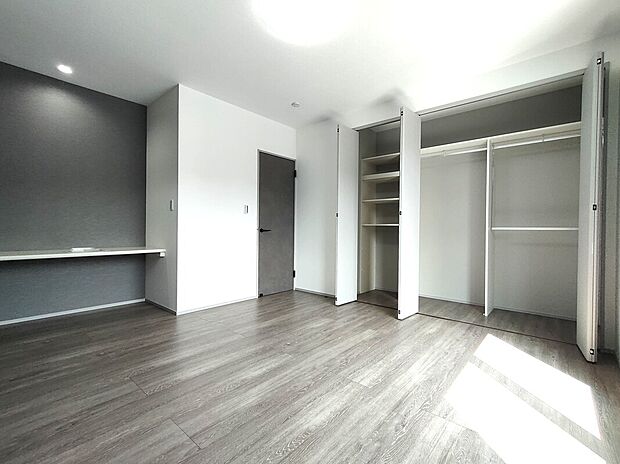 【主寝室(1号地)】9帖の主寝室は、落ち着いた色味でゆったり過ごせる空間。奥には棚とハンガーパイプ付きの収納があり、衣類や小物をすっきり整理でき、暮らしやすさを高めてくれます♪