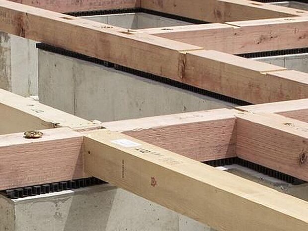 【剛性・耐久性にすぐれた「ベタ基礎」】コンクリートで建物の下一面を支える工法。　基礎鉄筋を張り、強度を高めたベタ基礎の耐圧盤を1階の床下全面に施工し、広い耐圧盤の面で建物の荷重を地盤に伝えます。
