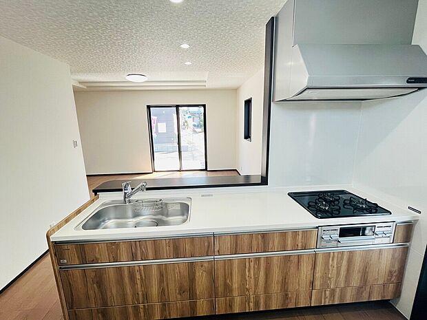 ナチュラルな木目調のデザインが印象的なキッチンです。広々としたワークトップで作業がしやすくガスコンロも使いやすい配置です。シンクと調理スペースのバランスが良くお手入れもしやすい設計です。