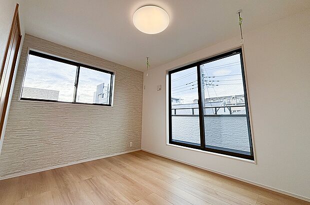 【リビング以外の居室】天井には便利な室内物干しを設置。共働き世帯や花粉の季節に嬉しい設備です。ナチュラルな内装にグレーの壁紙がアクセントになった、落ち着きのある寝室です。(1号棟)