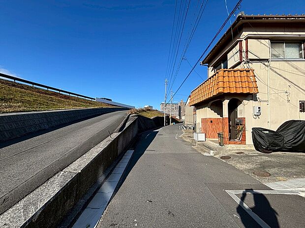 【現地外観写真】前面道路は、道路幅も広く、駐車もゆとりをもって行える環境になっています。お車の出し入れが苦手なママや小さなお子様にも安心ですね。舗装もされていて、ベビーカーや自転車で通っても快適に通行できます。