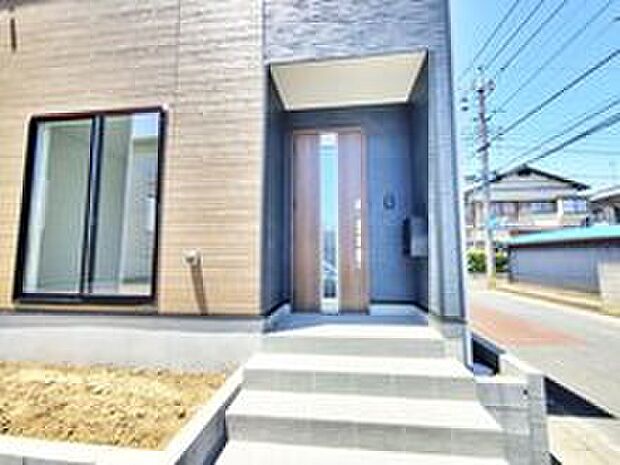 【現地外観写真】１号棟☆玄関ポーチには屋根がついているので雨などでも玄関前で濡れずにお出かけ準備が出来ます。訪れる人を優しく迎える、スタイリッシュな玄関。