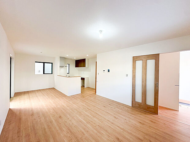 【リビング】ナチュラルな木目調フローリングと白の壁が、どんなインテリアにも映えるモダンな空間を演出。ご家族がゆったりとくつろげる広さと、団らんを育む心地よい明るさが魅力です。