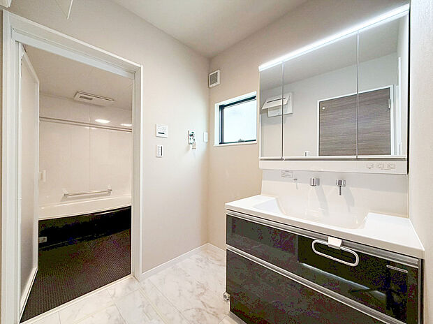 【洗面化粧台】たっぷりの大型収納を設けたシャワー付き洗面台で快適な暮らしを。収納力と機能性に優れたお手入れラクラクのゆったりとした洗面台で、朝の忙しい時間でも身支度準備がスムーズに出来そうですね。