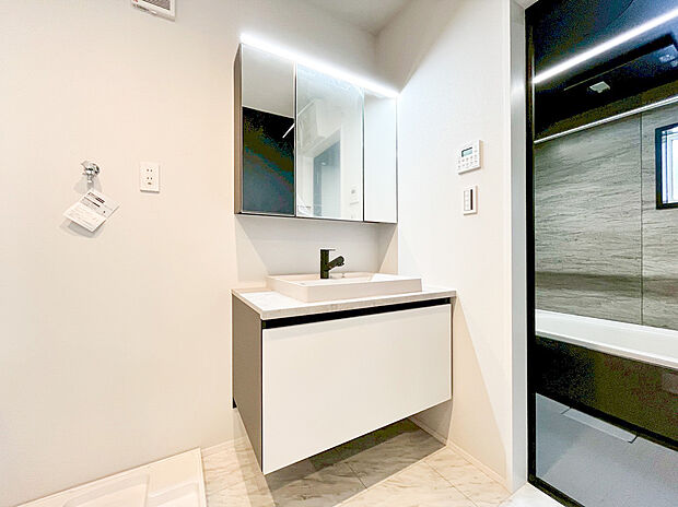 【洗面化粧台】モダンなフローティングデザインの洗面化粧台に、明るいLED照明付きのミラーキャビネットを装備。鏡裏収納で化粧品や小物がすっきり片付き、いつも清潔でスタイリッシュな洗面所です。