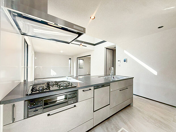 【類似仕様内観施工例(キッチン)】リビングに降り注ぐ明るい日差しがそのままキッチンにも柔らかく降り注ぐ明るい印象のキッチン廻り。リビングとキッチンの間に壁を設けてないフルオープンタイプですので、空間に一体感を感じられます。