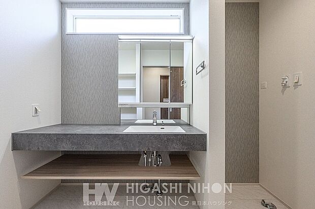 施工例（洗面）デザイン性と清潔感が調和した洗面室。上質な素材と洗練された照明が毎日の身支度を心地よい時間に変えてくれます。シンプルながらも美しく整う空間です。