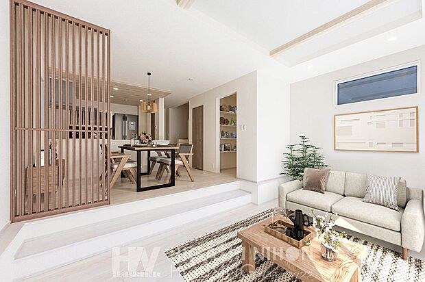 施工例（リビング）ホワイトと木のぬくもりが調和する、やさしい印象のリビング。自然素材の質感が心地よく、明るい光に包まれた上質な空間が、日常に癒しをもたらします。