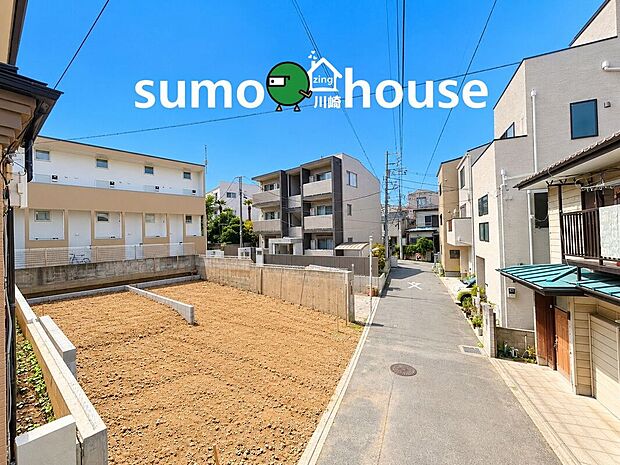 青空が広がる明るい現地。前面道路や周辺住宅との位置関係も分かりやすく、実際の暮らしをイメージしやすい環境です。