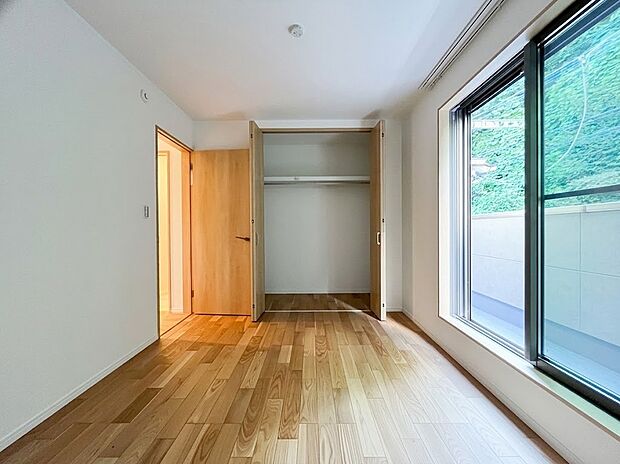 【居室4】木の温もりが心地よい明るい居室。大きな窓からは豊かな採光が差し込み、解放感をもたらします。大型のクローゼットを完備しているため、衣類や季節の荷物もすっきりと収納でき、お部屋を広く使えます。