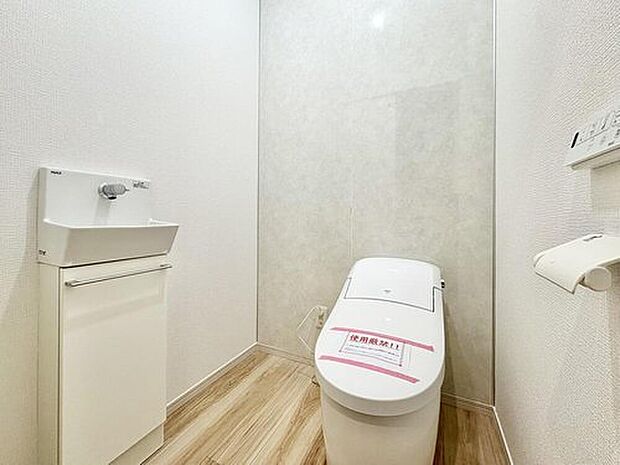 清潔感あふれるトイレは、手洗いシンクと収納キャビネット付きで機能性も抜群です。明るい空間で、家族みんなが快適に利用できます。