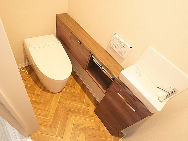 【施工例】毎日快適にご使用いただける、温水洗浄便座搭載のトイレ。独立した手洗い器が備わっています。
