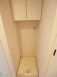 洗濯機置場には洗濯パンが設置されていて上部には棚があり、サニタリー用品の収納場所も確保されています。