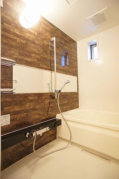 画像12:換気と採光を考慮した小窓があって明るく清潔感あるバスルームは、沸かし直しができる追焚給湯機能付き♪ダーク系のアクセント壁がモダンな印象の浴室は、あなたを癒すリラックス空間♪