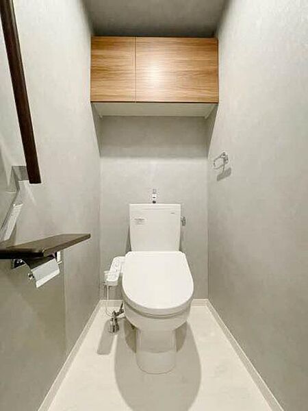 画像10:【トイレ】シックで落ち着きのあるトイレ内装です。ペーパー類をストックするのに便利な、戸棚を上部に設置しました。
