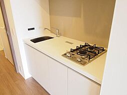 2口コンロ付のコンパクトなキッチン。調理スペースが広がるトレイ付きです。キッチン周りはお手入れの簡単なキッチンボード採用。