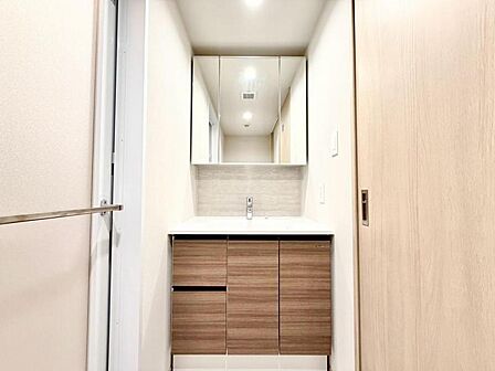 三面鏡の裏は機能的な収納を配置。コンセントも付いているため電動シェーバーや、電動歯ブラシも収納できます。