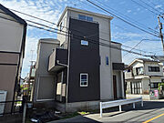 角地ならではの開放感を感じられる外観デザインが魅力の新築住宅。ツートンカラーの外壁がスタイリッシュな印象を与え、縦のラインを強調した立体感あるフォルムも特徴です。