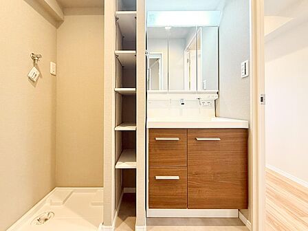 三面鏡付きの洗面化粧台はリフォーム済で清潔感のある仕上がりです。鏡裏収納に加え、横には可動棚も備わり収納力良好。洗濯機置場も同空間にあり家事動線に配慮された設計です。