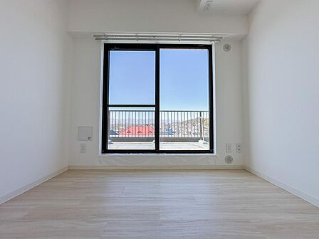 大きな窓からは開放的な景色が広がります。高層階ならではの抜け感と陽当たりが魅力の一室です。