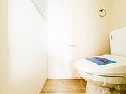 白を基調とした、清潔感あふれるトイレ空間。スリット窓から自然光が差し込み、明るく爽やかな印象を与えます。温水洗浄便座付きで、毎日を快適に過ごせる機能性もしっかりと備わっています。