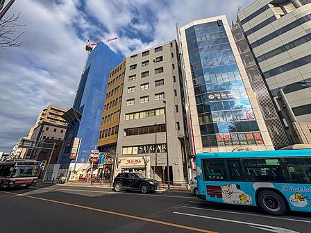 カラフルなバスが行き交う賑やかな街並み。商業施設も充実し、家族でのお出かけが楽しくなる環境です。