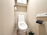 快適な温水洗浄便座付きトイレ。頭上の収納スペースもしっかり確保されており、トイレットペーパーのストックや掃除用具もスッキリ片付きます。