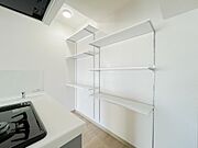 キッチン横には収納棚があり、パントリーとしてもお使いいただけます。
