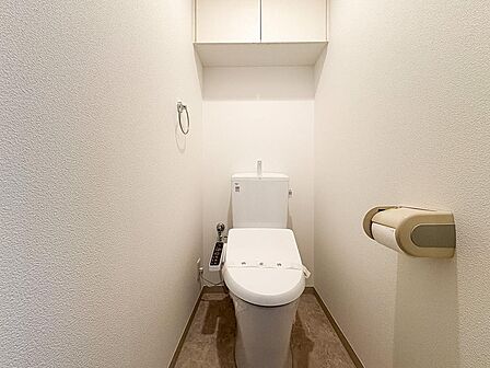 快適な温水洗浄便座付きトイレ。頭上の収納スペースもしっかり確保されており、トイレットペーパーのストックや掃除用具もスッキリ片付きます。