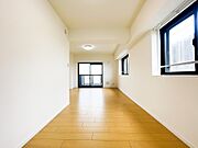 直線的で奥行きがあり、家具の配置がしやすい広々としたリビングスペース。明るいナチュラルカラーのフローリングと白壁が室内の隅々まで光を広げ、家族みんながゆったりと快適に寛げる心地よい空間です。