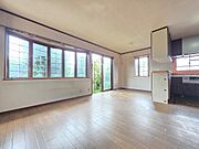大きな開口部から庭の緑を望む開放感のあるLDKです。リフォームによりキッチンや水廻り設備の交換を予定しており、住まいの中心となる空間が新しく生まれ変わります。