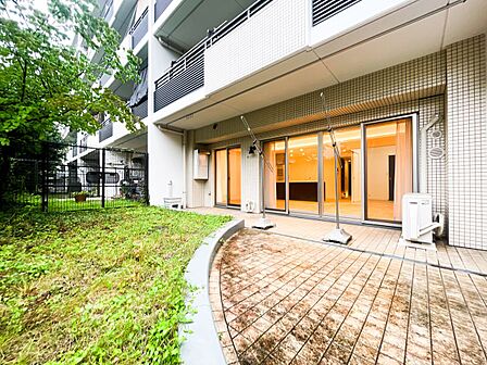 専用庭へと繋がる、タイル敷きの広々とした庇(ひさし)付きテラス。洗濯物干しに便利な設備を完備しているほか、外からの視線を遮る高い生垣があるため、プライバシーを守りつつおうちカフェや読書をのんびり楽しめ