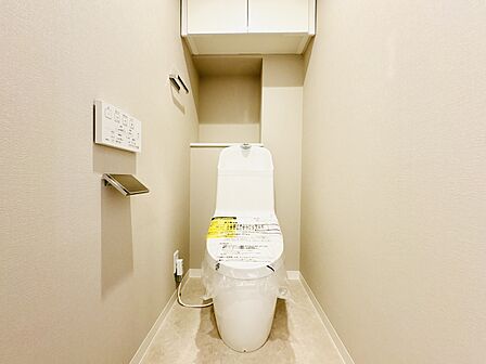 新規交換済みの清潔感あふれるトイレ。上部には便利な吊戸棚付きで空間をすっきり保てます。
