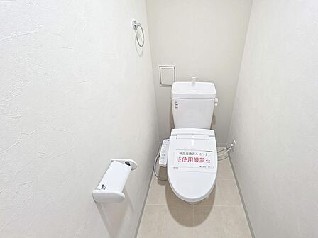 清潔感のあるすっきりとしたトイレ空間。温水洗浄機能付き便座を備え、毎日快適に使用できます。シンプルにまとめられた内装で、お手入れのしやすさにも配慮されています。