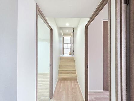室内をつなぐ廊下は、段差を設けた特徴的な設計。各居室へアクセスしやすい動線が確保され、奥まで視線が抜けることで住まい全体に広がりを感じられる空間です。