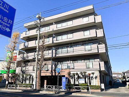 青空に映える重厚感のあるタイル貼りのマンション外観。落ち着いた住環境です。