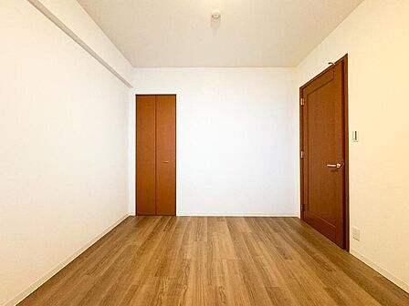 明るい木目調のフローリングが心地よい洋室。収納も完備しており、お子様の成長に合わせて多目的に活用できる、家族に寄り添う空間です。
